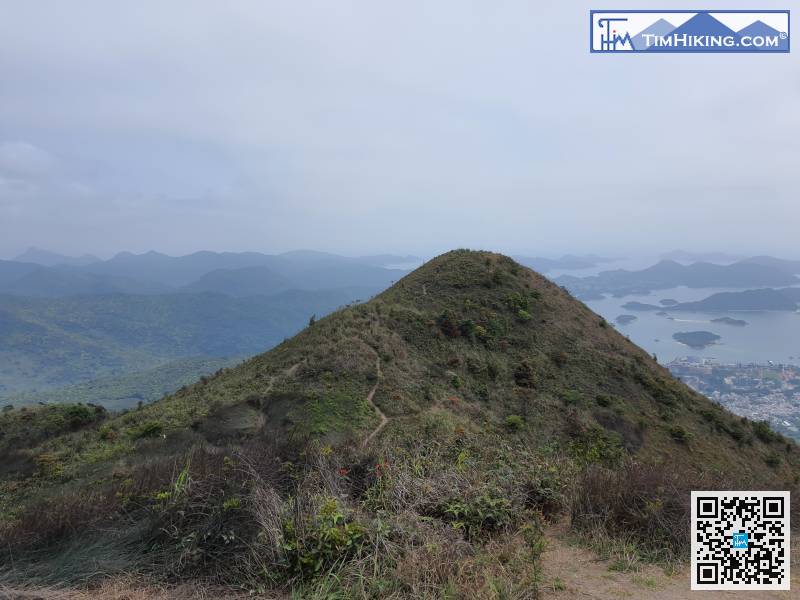 面對靚景，不要急着落山，先左轉前往仙人點將台，就在左邊的小山丘之下。